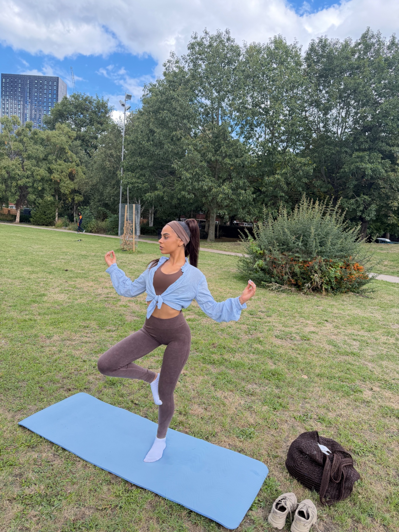 Ana in a balancing yoga pose in a Manchester park