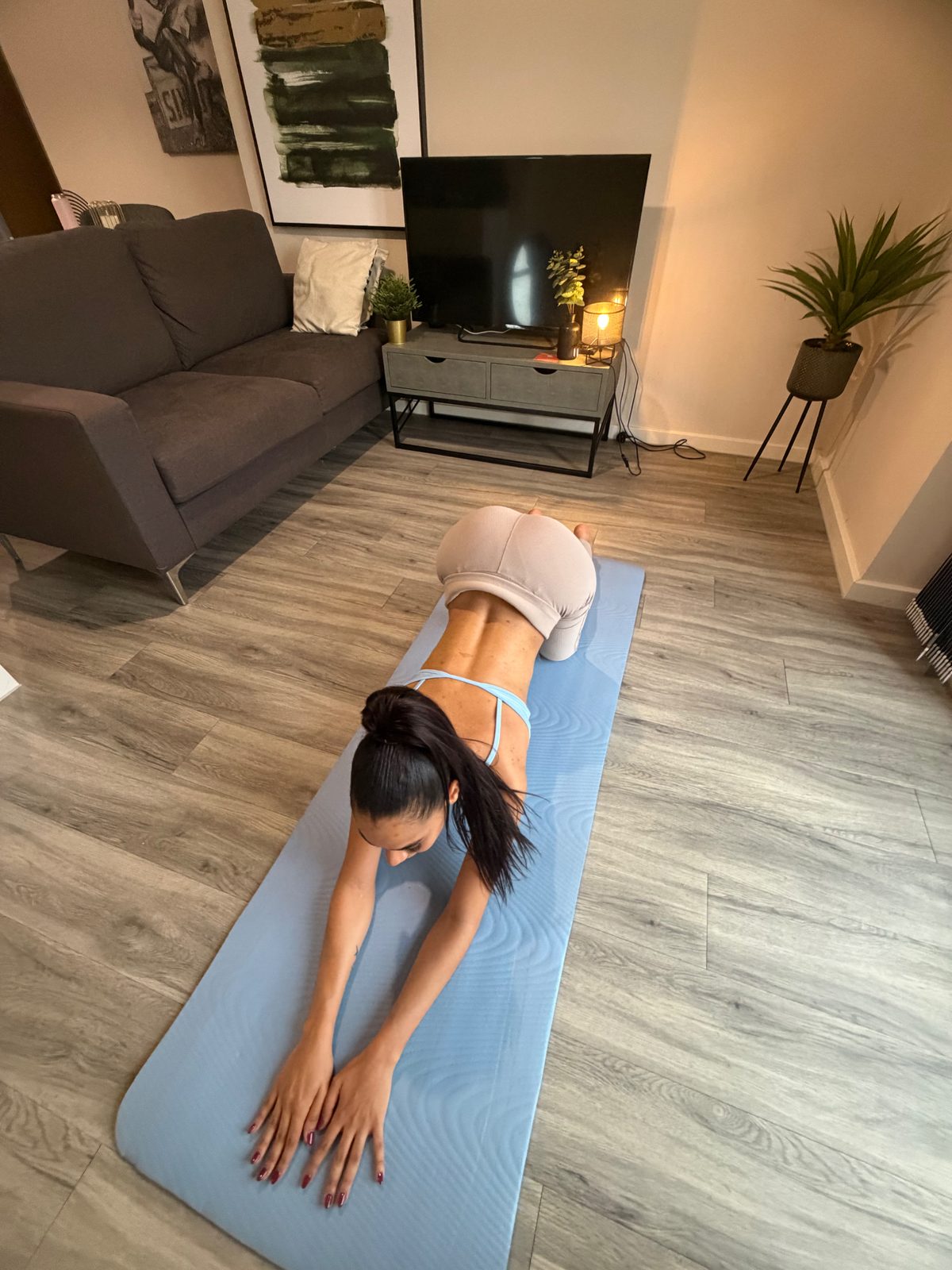 Ana in a gentle stretch on all fours on a light blue mat